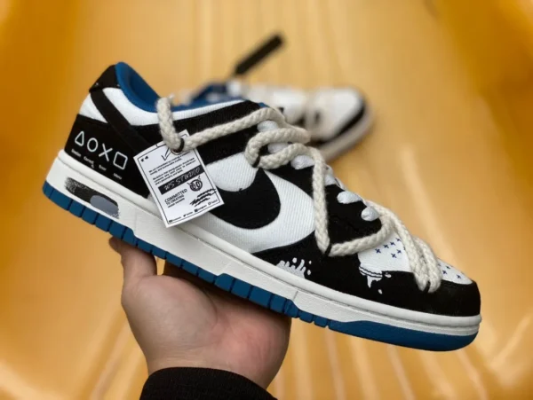 Dunk-Riemen aus schwarz-weißem, blauem Denim. Niedrig geschnittene Nike Dunk Low Retro „Black“-Sneaker im dekonstruierten Dark-Night-Messenger-Buchstaben-Graffiti-Stil DV0834-101